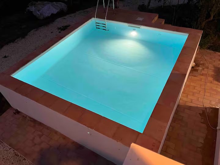 Piscina da casa MonteZinho iluminada ao anoitecer